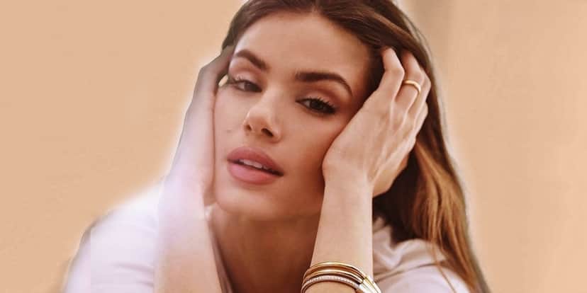 Camila Queiroz é uma mulher de pele branca, cabelos castanhos lisos longos e está com as mãos no rosto Camila Queiroz é uma mulher de pele branca, cabelos castanhos lisos longos e está com as mãos no rosto