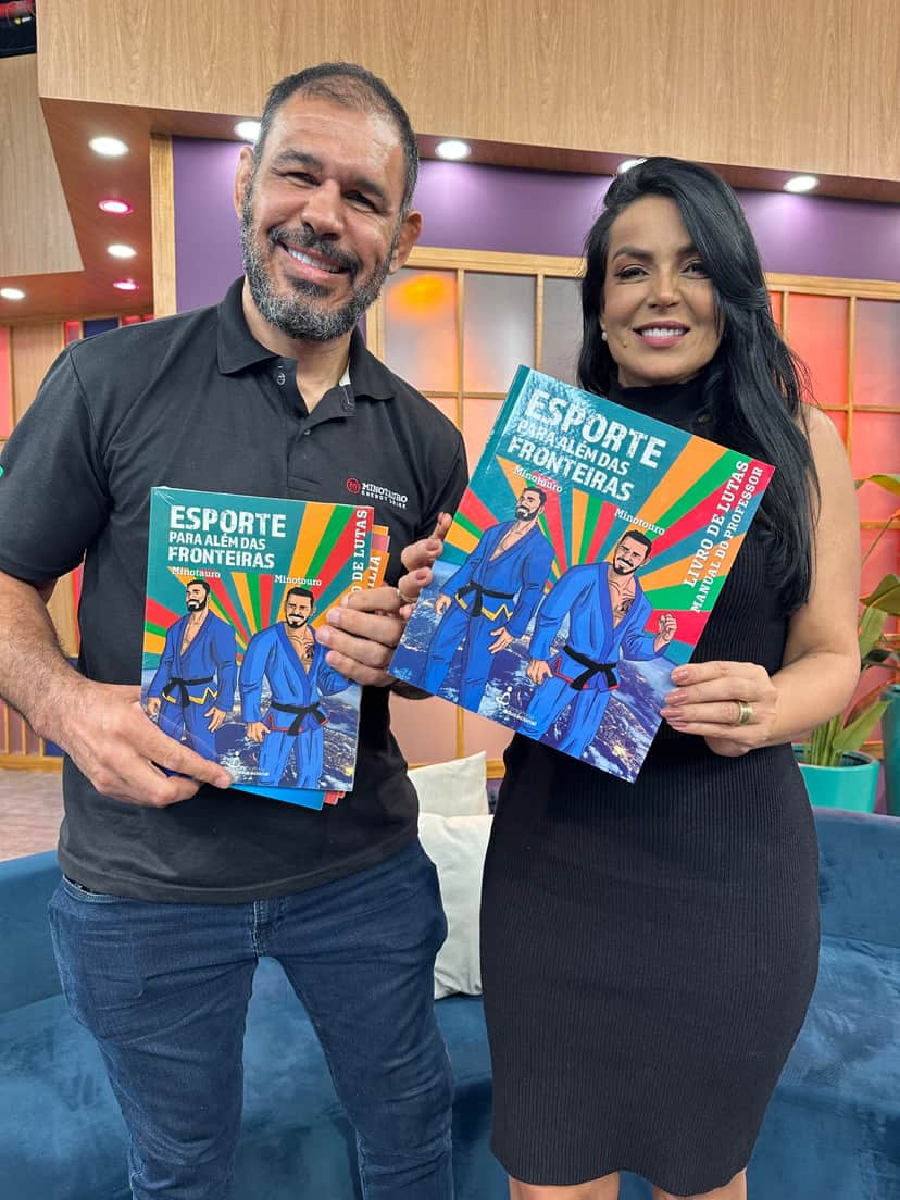 Rogério Minotouro e Gardênia Cavalcanti com o livro "Esporte Para Além das Fronteiras" (Foto: Divulgação/Band Rio)