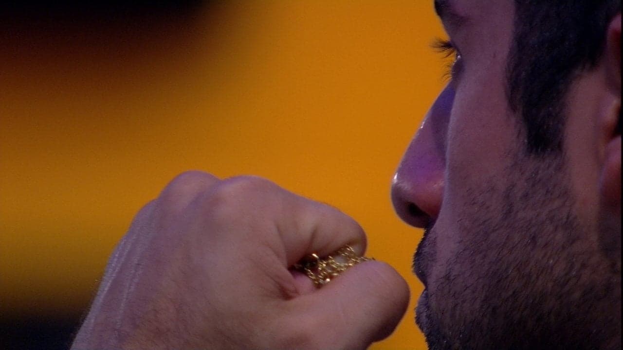 Kaysar segura corrente com foto da família e fica pensativo no jardim (Foto: Reprodução)