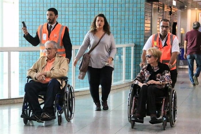 Tarcísio Meira e Gloria Menezes embarcam de cadeira de rodas no aeroporto Santos Dumont no Rio (Foto: Audrey Assed/AgNews)