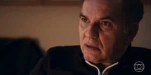 Guerra homem branco usando blusa de frio azul escura com detalhe no zíper em branco com expressão chocada em cena da novela Travessia Guerra homem branco usando blusa de frio azul escura com detalhe no zíper em branco com expressão chocada em cena da novela Travessia