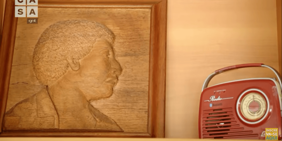 Quadro de madeira retratando o pai de Diogo Nogueira ao lado de um rádio antigo (Foto Reprodução/Youtube)