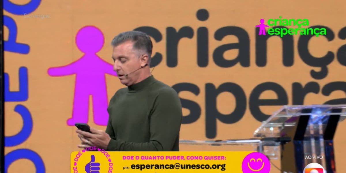 Luciano Huck fez questão de mostrar a sua doação para o programa solidário (Reprodução: Globo) Luciano Huck fez questão de mostrar a sua doação para o programa solidário (Reprodução: Globo)