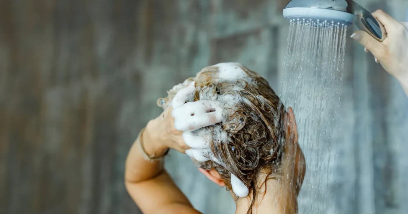 Mulher lavando o cabelo com shampoo (Reprodução: Canva) Mulher lavando o cabelo com shampoo (Reprodução: Canva)