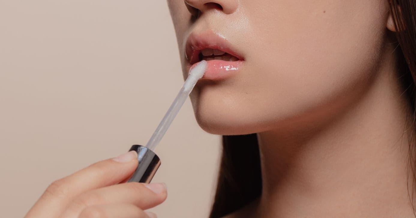 Mulher passando batom da Avon (Foto: Canva) Mulher passando batom da Avon (Foto: Canva)