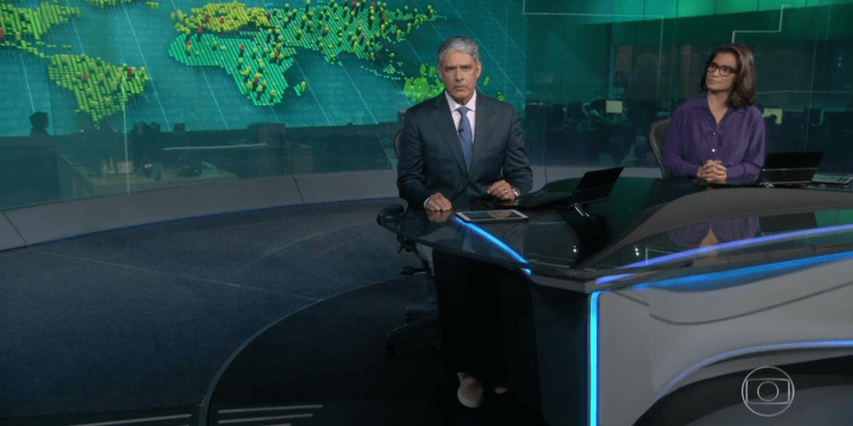 William Bonner de usando calça jeans e tênis esportivo na bancada do Jornal Nacional William Bonner de usando calça jeans e tênis esportivo na bancada do Jornal Nacional